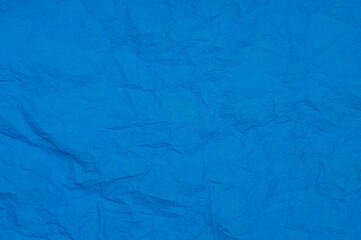 Fototapeta premium Rumpled embossed closeup napkin texture. Classic blue background