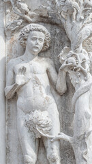 Ancient aged sculpture of beautiful Eva with apple and Adam from Bible story of Creation at Doge Palace in Venice, Italy, closeup, details