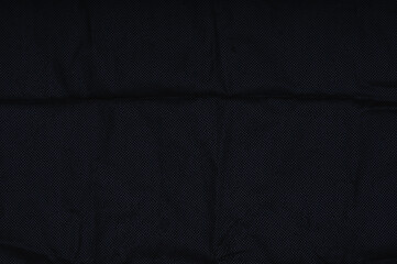 black non-woven texture closeup. Wrinkled material