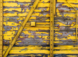 Yellow painted peeled wood train wagon texture background