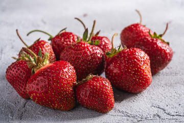 Fresh ripe strawberry fruits, summer vitamin berries on grey stone background, angle view macro
