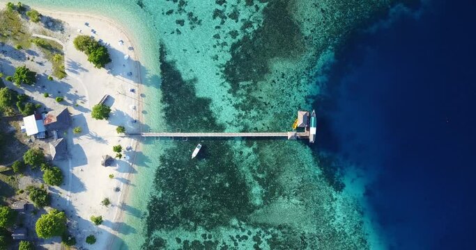 Amazing blue lagoon and barrier reef in Kanawa Island, top-down view with pontoon and boats, near the city of Labuan Bajo on Flores, Indonesia, travel destination in Asia