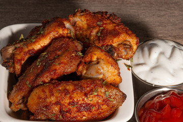 chicken wings in a white dish with sauce