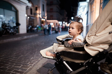 a little girl in a stroller on the street of the old city