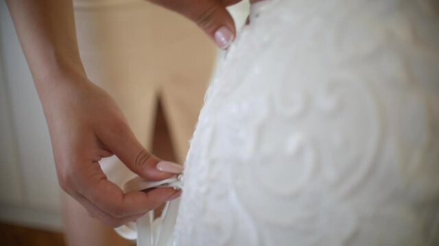 Buttoning and trimming the wedding dress