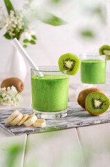 Fruit smoothie with kiwi and banana on a white wooden table