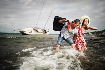 Man and woman escaped from their sunken yacht after storm. Concept with humor. 