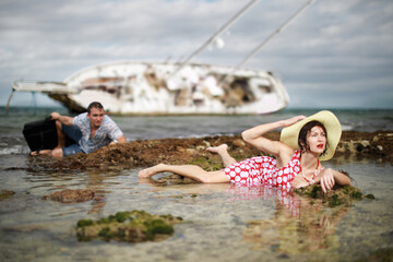 Man and woman escaped from their sunken yacht after storm. Concept with humor. 