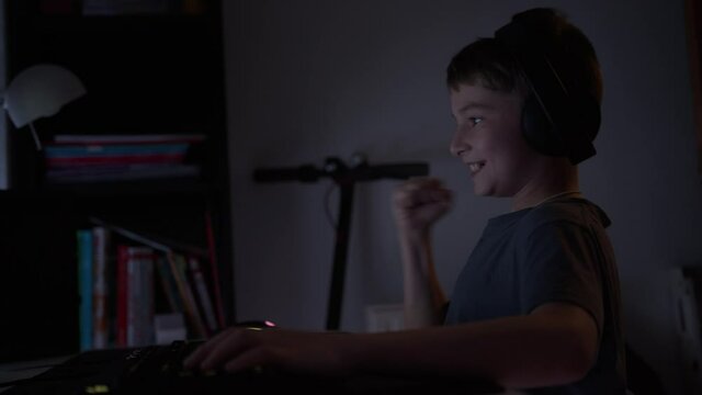 boy plays computer games on the console celebrates victory