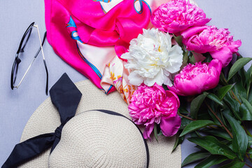 Mix peony bouquet, female straw hat, sunglasses and silk scaft on lilac background. Top view. Idea for poster, wallpaper
