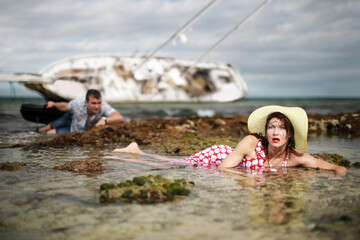 Man and woman escaped from their sunken yacht after storm. Concept with humor. 