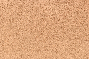 Texture of rustic exterior textured coating on the wall. Peach color, rustic exterior texture paint, background idea concept