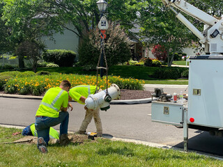 A fire hydrant is worked on by city maintenance workers.