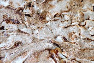 Texture of home-made crumble cake with strawberry jam covered with meringue. Streuselkuchen, cake background, close-up