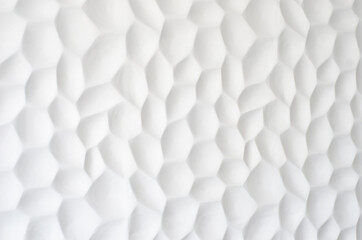 White wall with a wavy texture. Gypsum panels with geometric patterns. Embossed wall in neutral...