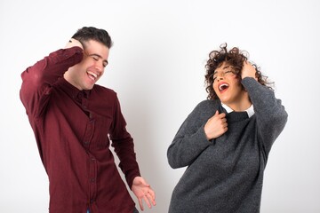Shot of happy young woman with positive smile, has long hair, rejoices having weekend and good rest after hard working exhausting week, isolated on gray wall.