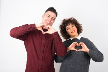Beautiful caucasian woman over isolated background smiling in love showing heart symbol and shape with hands. Romantic concept.