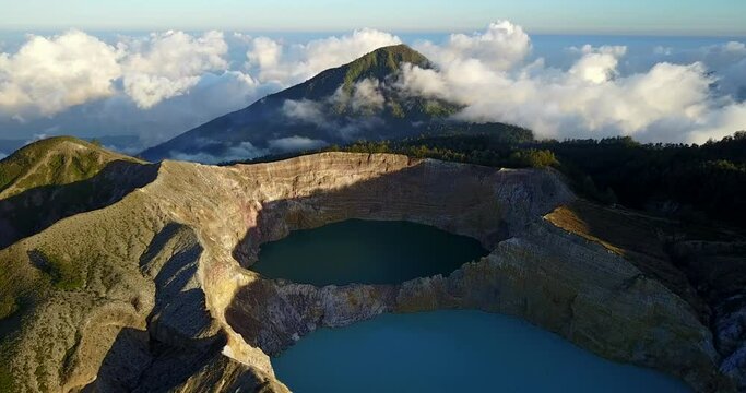 Aerial forward flying view of Kelimutu volcano and its beautiful tri-colored lakes on Flores island, famous travel destination in Indonesia and Asia 