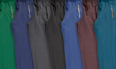 Background with folded set multi-colored jogging pants. 
