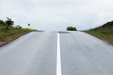 long lonely old asphalt road with a white solid stripe