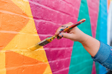 Artist painting a wall with a brush - obrazy, fototapety, plakaty