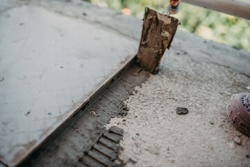 skilled worker installing the ceramic wood effect tiles on the floor Worker making laminate flooring on the construction site of the new apartment