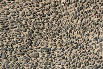 old cobbled medieval ground with round black stones - background texture wallpaper