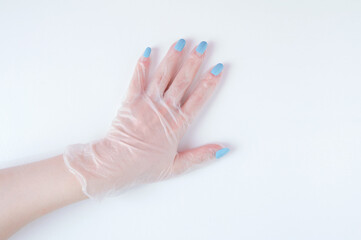 Manicure on a woman hand on top of protective glove on a white background.