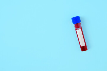 Blood in plastic test tube on blue background. View from above.