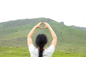 woman hand heart sign in  mountain