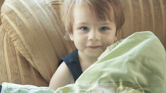 Boy hiding under a blanket