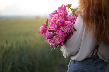 Beautiful girl with a bouquet peony