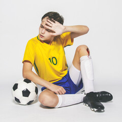Male child soccer player wiping sweat from his face