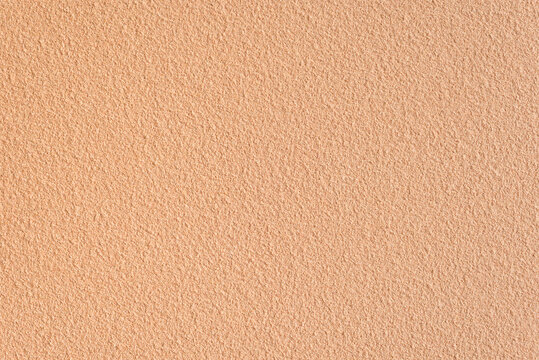 Textured sand background closeup. Decorative wall plaster, interior decoration. Background image of a wall with a beige textured coating.