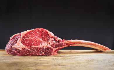 Dry aged wagyu tomahawk steak on a wooden cutting board
