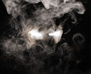 Ominous luminous eyes looking out of the darkness illuminate the swirling smoke with rays of white light