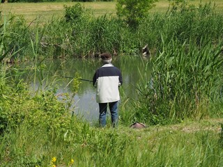 Budapest, hungary - june 03, 2020: Old man fishing at a lake in Budapest suburb 