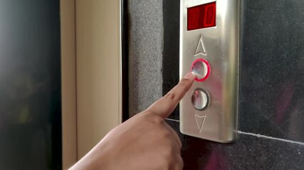 Close up of Young female hand pushing / pressing elevator / lift button up in Office Center or Hotel or home apartment