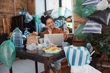 Young female doing selfie surrounded by piles of rubbish