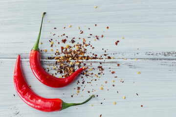 Overhead of assorted spices and chili peppers on white wooden table. Seasonings background with...