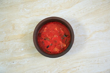 Tasty south indian fish curry isolated on floor background