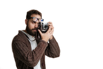 Confident hipster photographer taking picture and looking in a viewfinder of photo camera