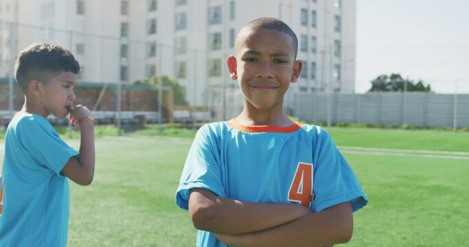 African American soccer kid in blue smiling and looking at camera