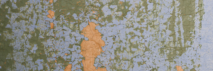 Peeling paint on the wall. Panorama of a concrete wall with old cracked flaking paint. Weathered rough painted surface with patterns of cracks and peeling. Wide panoramic texture for grunge background