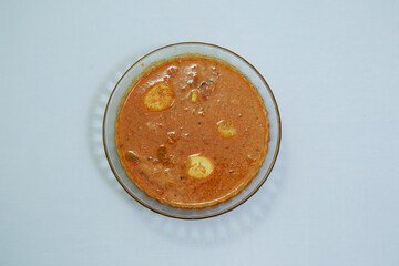 Tasty south indian egg curry in a glass bowl isolated on white
