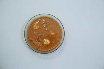 Tasty south indian egg curry in a glass bowl isolated on white