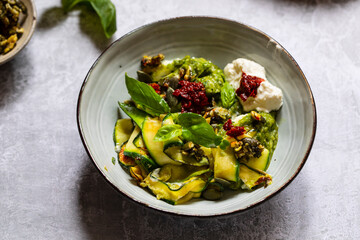Vegetarian dish with courgette, pesto and pumpkin seeds