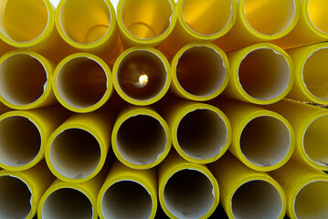 yellow plastic pipes for laying electricity cables underground. texture or abstract background.