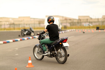 Fototapeta na wymiar Driving school driving lessons. Motorcyclist on a motorcycle. young man learning how to drive motorbike. Driving instructor advising man driving a motorbike. Close up of a motorbiker hand starting.