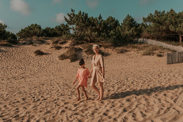mother and daughter walking on the sand